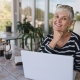 elderly woman smiling while at her laptop