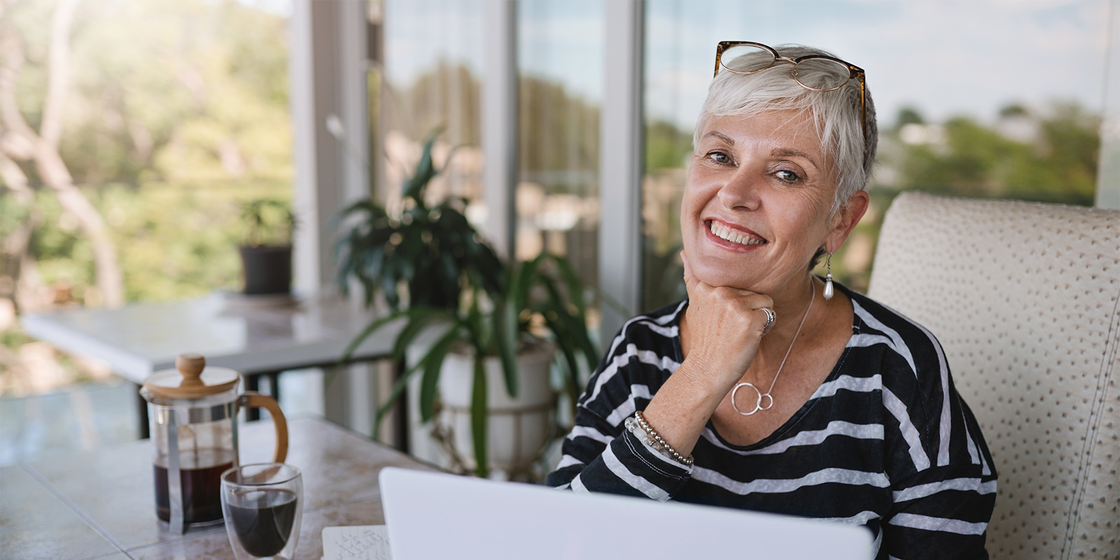 elderly woman smiling while at her laptop