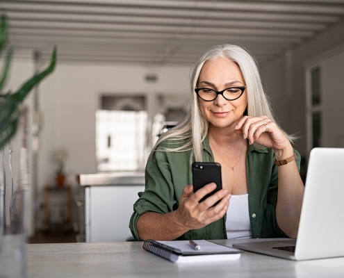 business woman smiling at her phone at her desk