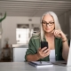 business woman smiling at her phone at her desk
