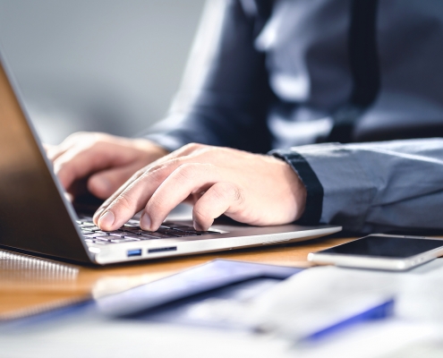 Person typing on computer learning about the Secure 2.0 Act chnages.